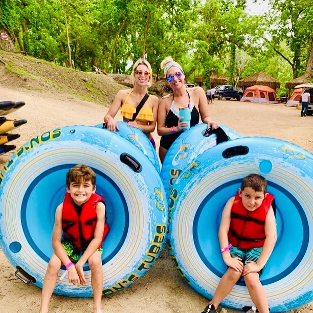 Family relaxing at a riverside cabana at Son's River Ranch