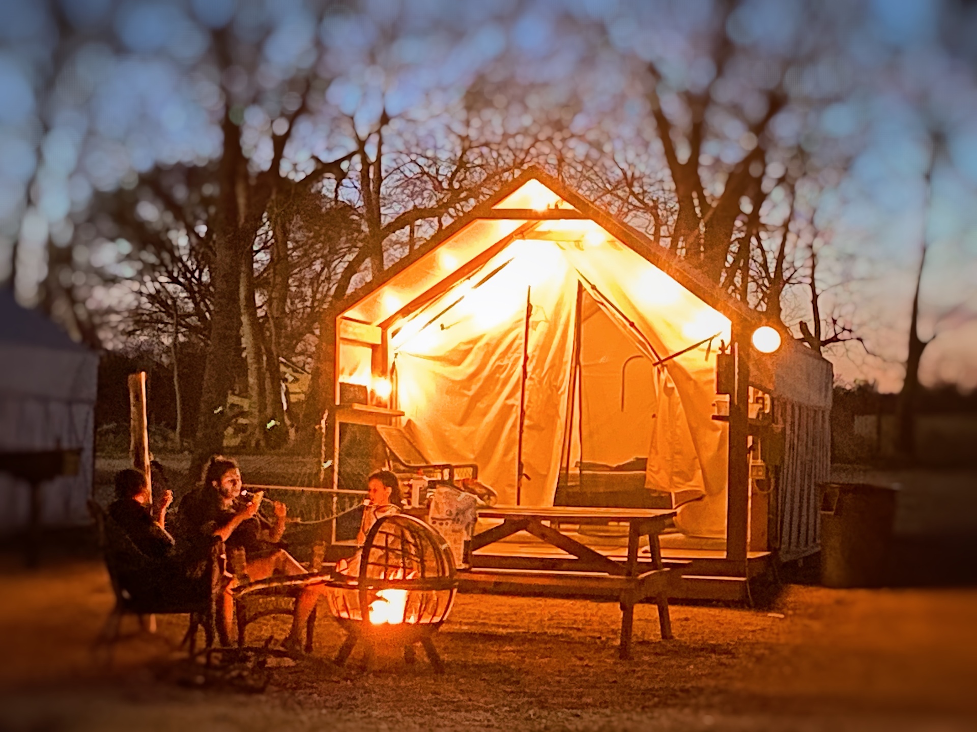 Family gathered around a fire pit at Son's River Ranch in the evening